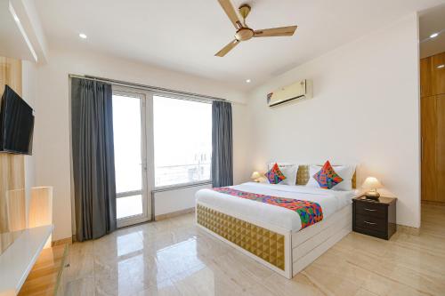 a bedroom with a bed and a large window at FabExpress AR Suites in Gurgaon