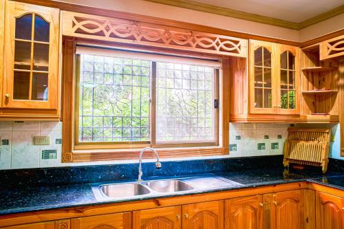 a kitchen with wooden cabinets and a sink and a window at La Veranda Tagaytay in Tagaytay