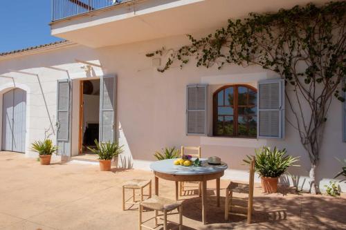 a patio with a table and chairs in front of a house at Sa Nau Agroturismo - Adults Only over 16 in Portocolom