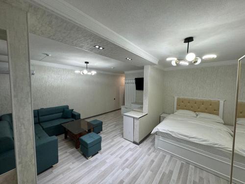 a bedroom with a bed and a couch and a table at Toshkent Hotel in Andijan