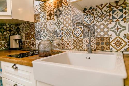 a white sink in a kitchen with tiles at La casita de vanessa in Telde