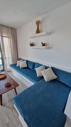 a living room with a blue couch and a table at Villa Meraki in Kastraki
