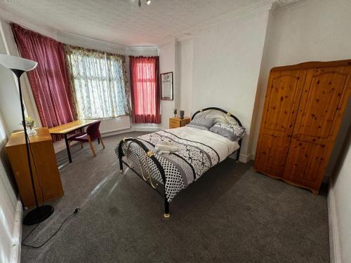 a bedroom with a bed and a table and windows at Double-Bedroom in the Heart of Salford Manchester Perfect for Short Stays GCSW5 in Manchester