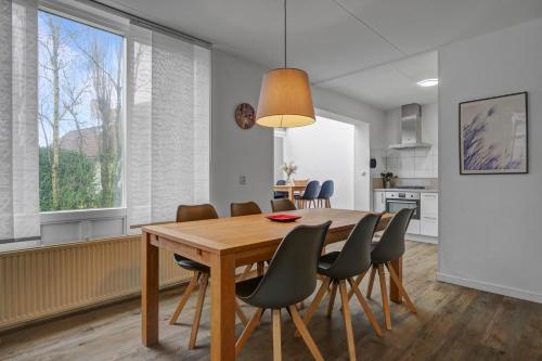a kitchen and dining room with a wooden table and chairs at Villa Beatrix - Landal park Ooghduyne Julianadorp aan Zee in Bruggenmors