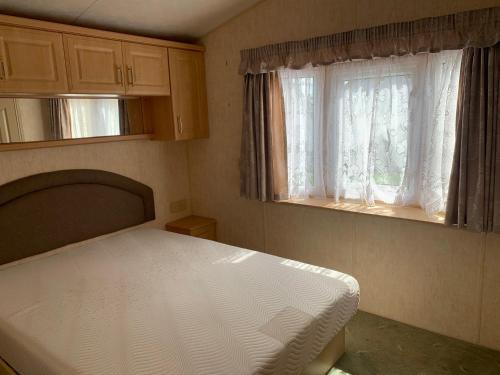 a small bedroom with a bed and a window at Ferienhaus im Villengarten in Neustadt am Kulm