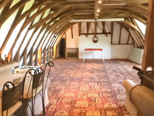 Cette chambre mansardée comprend une table et des chaises. dans l'établissement Manoir charmant à Saint-Genès-du-Retz, à Saint-Genès-du-Retz