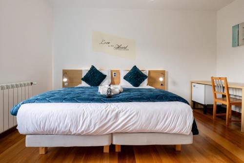 a bedroom with a bed with a blue comforter at Casa Os Manos in Santana