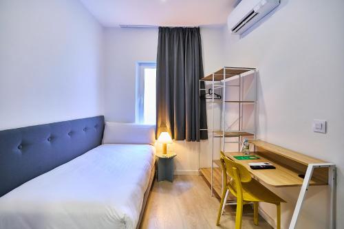 a bedroom with a large bed and a desk and a desk at Hotel Gran Vía by gaiarooms in Salamanca