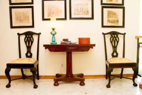 two chairs and a table with a lamp in a room at Challet Fonte Nova in Alcobaça