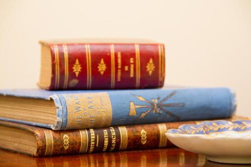 a stack of books sitting on a table with a bowl at Challet Fonte Nova in Alcobaça