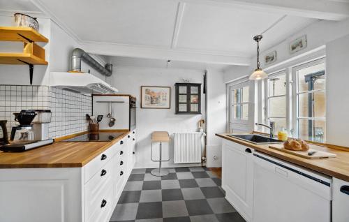 a kitchen with white cabinets and a checkered floor at Lovely Home In Marstal With Wifi in Marstal