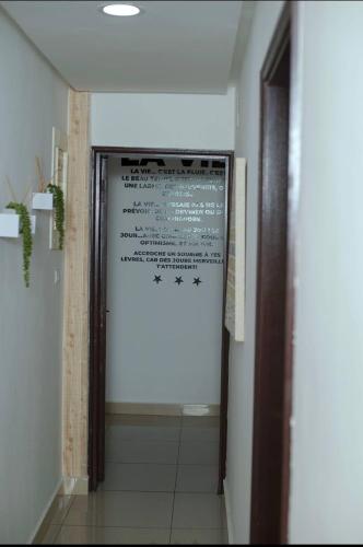 a door in a hallway with a sign on the wall at Appartement cosy Green bonapriso in Douala
