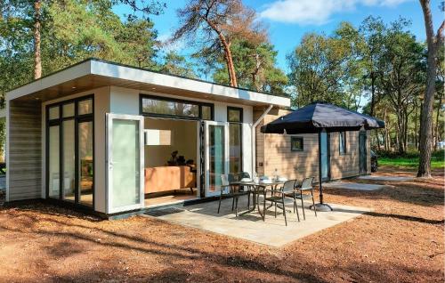 a small house with a table and an umbrella at 2 Bedroom Lovely Home In Hellendoorn in Hellendoorn