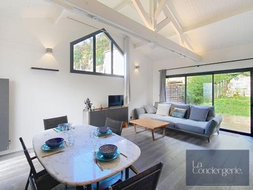 un salon avec une table et un canapé dans l'établissement Le Jardin du Clain - Poitiers Centre - LaConciergerie, à Poitiers
