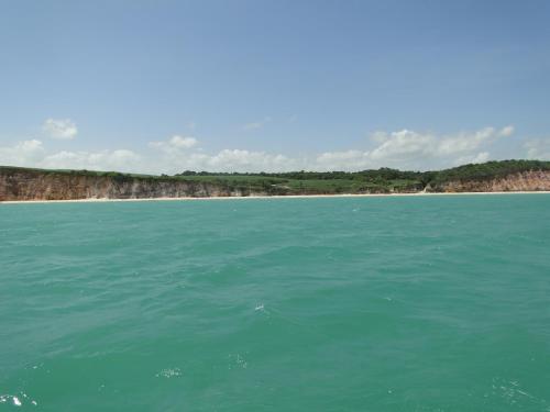 a body of water with a beach in the background at Hotel Pousada Arco Iris in Barra de Santo Antônio
