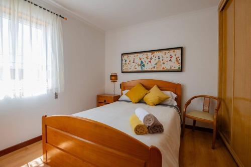 ein Schlafzimmer mit einem großen Bett mit gelben Kissen in der Unterkunft Milfontes' Shelter in Vila Nova de Milfontes