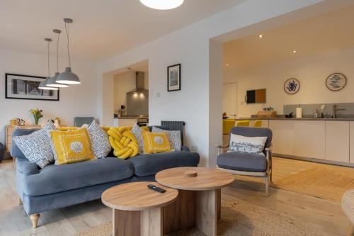 a living room with a blue couch and two tables at Silver Shore in Southwold
