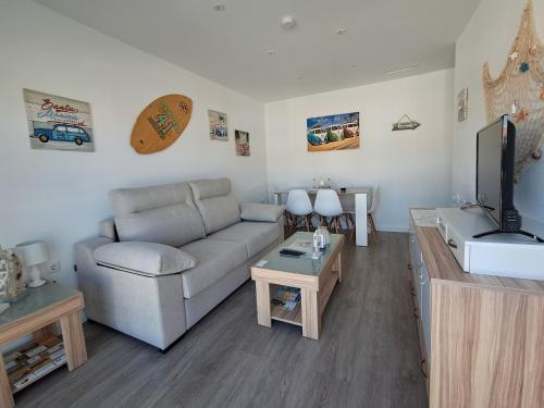 ein Wohnzimmer mit Couch und Flachbildfernseher in der Unterkunft Beach House in Puerto de Mazarrón