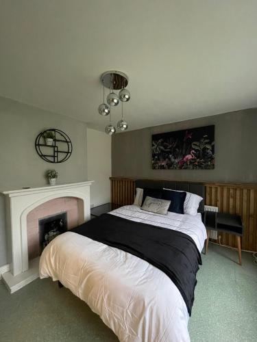 a bedroom with a large bed and a fireplace at serenity suite musden walk in Manchester