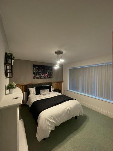 a bedroom with a large bed and a window at serenity suite musden walk in Manchester