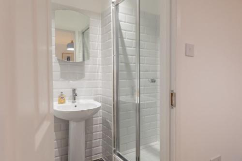 a white bathroom with a sink and a shower at Silver Shore in Southwold