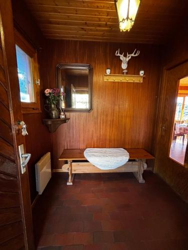une pièce avec un banc et un miroir dans une pièce dans l'établissement Chalet avec superbe vue dégagée - 10 min de Gérardmer, à Ban-sur-Meurthe-Clefcy