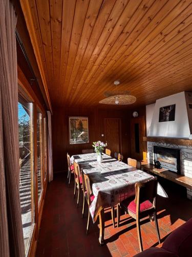 une salle à manger avec une longue table et des chaises dans l'établissement Chalet avec superbe vue dégagée - 10 min de Gérardmer, à Ban-sur-Meurthe-Clefcy