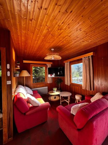 - un salon avec deux canapés rouges dans une cabine dans l'établissement Chalet avec superbe vue dégagée - 10 min de Gérardmer, à Ban-sur-Meurthe-Clefcy