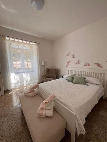 una camera da letto bianca con un letto grande e una sedia di Dominicus I a Briatico