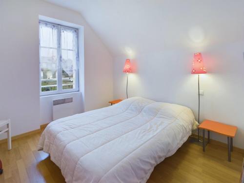 a white bedroom with a bed and two lamps at À 110 m de la plage, maison pour 6 personnes in Concarneau