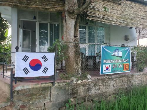 two signs on a fence in front of a house at Guest house weherahena in Matara