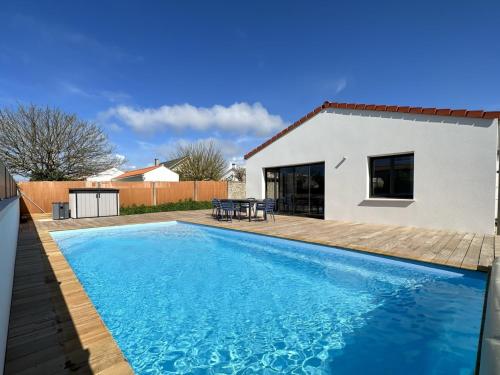 une piscine devant une maison dans l'établissement Maison 6 avec piscine chauffée à St-Hilaire, à Saint-Hilaire-de-Riez
