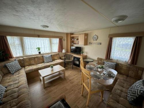 a living room with a couch and a table at The Chase i35 - pet friendly, Wifi, bed linen - Meadow Lakes Caravan & Lodge Hire in Ingoldmells