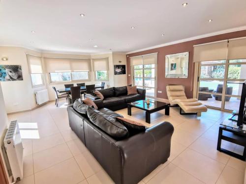 a large living room with a couch and a table at Orchard Blossom Private Villa With Pool in Phrenaros
