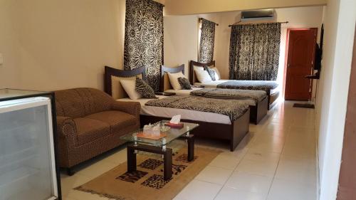 a living room with two beds and a couch at Royal Inn Hotel in Karachi