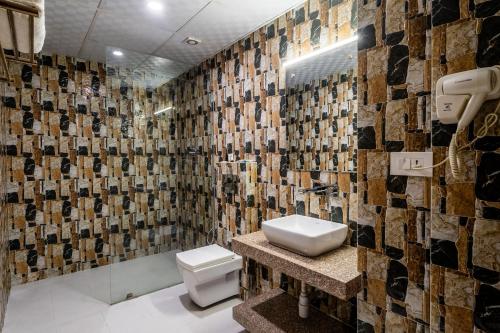 a bathroom with a toilet and a tile wall at Hotel Yukhang in Kathmandu