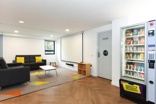 a living room with a couch and a refrigerator at For Students Only Corfe House in Poole in Poole