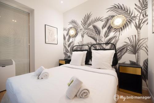 une chambre avec un grand lit blanc avec des serviettes dessus dans l'établissement CIA - Saint-Germain Notre Dame, à Paris