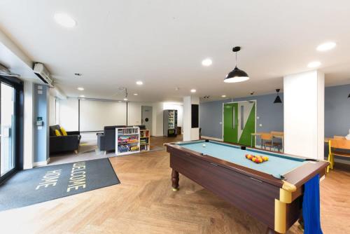 a living room with a pool table in the middle at For Students Only Corfe House in Poole in Poole