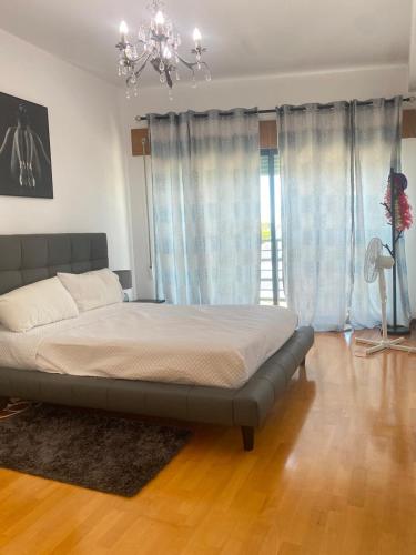 a large bed in a bedroom with a chandelier at Great V4 Villa with Private Salt Pool in Quinta do Anjo