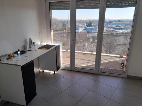 un bureau avec un bureau et une grande fenêtre dans l'établissement L'étoile, à Toulouse