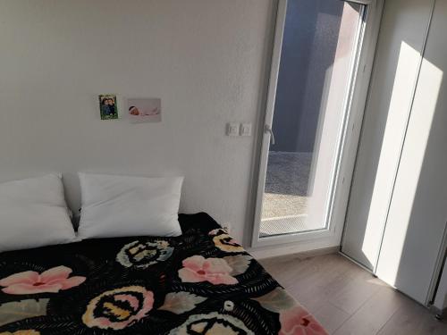 - une chambre avec un lit doté d'une couverture de fleurs dans l'établissement L'étoile, à Toulouse