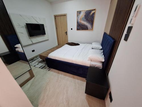 a small bedroom with a bed and a mirror at Nara Luxe -- 24hours Power Supply, Board games, Pool and Gym in Lagos