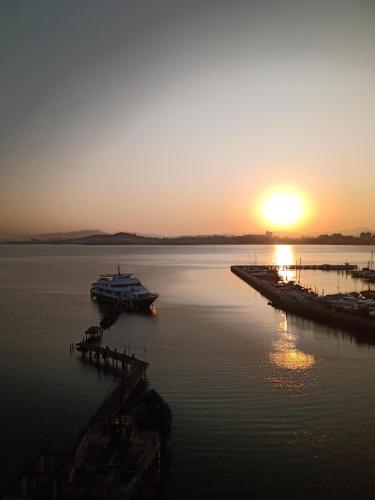 a boat is docked at a dock at sunset at Hotel Veleiro in Florianópolis