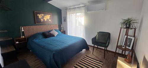 - une chambre avec un lit bleu et une chaise dans l'établissement Le havre de paix - Maison familiale avec piscine et climatisation, à Sauvian