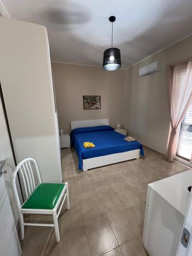 a bedroom with a blue bed and a chair at casa vacanze GLICINE Zambrone in Zambrone
