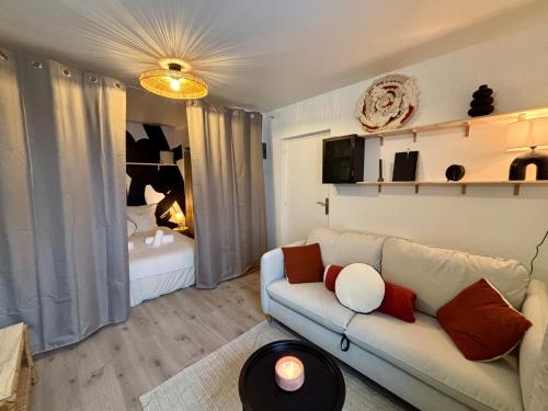 a living room with a couch and a bedroom at Limone Guest - Appartement Cosy - 5 min des plages in Larmor-Plage