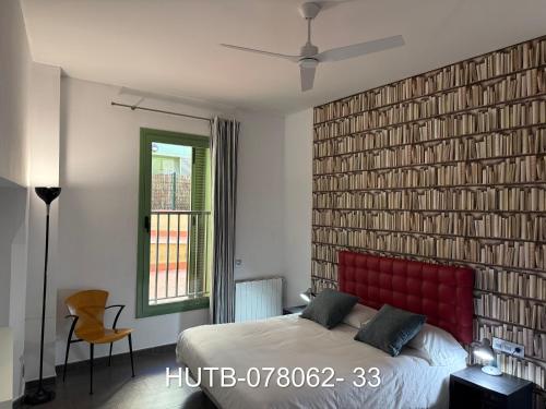 1 dormitorio con una gran pared de ladrillo y cabecero rojo en Palau de la música 2, en Barcelona