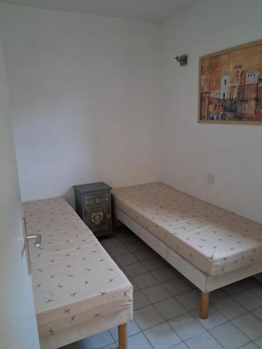 une chambre avec deux lits et une table dans l'établissement Les jonquières à Gassin, avec piscine collective 26, à Gassin