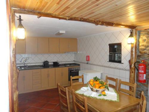 eine Küche mit einem Tisch und einer Obstschale darauf in der Unterkunft Abrigo do Outeiro - Serra Da Estrela in Cabeça